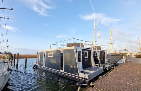 Woonboot Havenlodge Lelystad aangemeerd bij Marina Parcs Lelystad in Nederland aan een mooie aanlegsteiger.