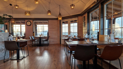 Interior acogedor de restaurante en la casa flotante Havenlodge Lelystad en Marina Parcs Lelystad, Países Bajos.