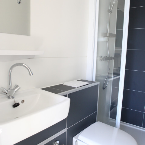 Moderne badeværelse på en husbåd, med håndvask, toilet og bruser hos Marina Parcs Lelystad i Holland.