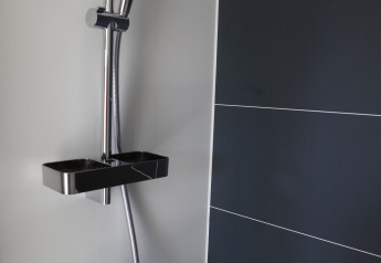 Douche moderne sur une péniche à Havenlodge Lelystad, Marina Parcs Lelystad, Pays-Bas, avec carrelage foncé.