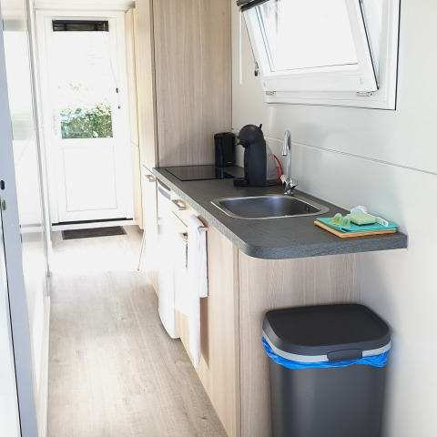Moderne Küchenzeile auf einem Hausboot mit Spüle, Kaffeemaschine und großem Fenster in Lelystad.
