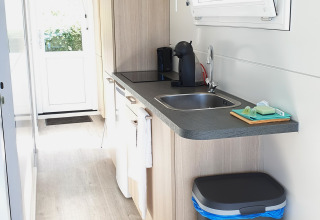 Moderne kitchenette op een woonboot met gootsteen, koffiezetapparaat en raam bij Marina Parcs Lelystad.