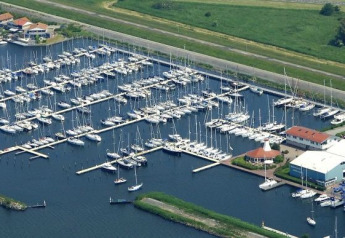 Luchtfoto van Marina Parcs Lelystad in Nederland met veel boten en steigers bij Havenlodge Lelystad.