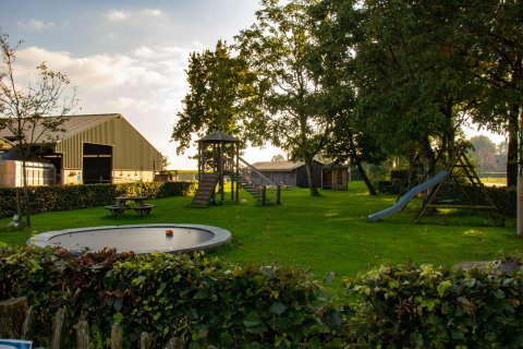 Parque infantil con tobogán, trampolín y mesas de picnic en Feather Down De Brabantse Hei, Brabante Septentrional, Países Bajos.