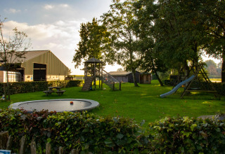 Speeltuin met glijbaan, trampoline en picknicktafels bij Feather Down De Brabantse Hei in Noord-Brabant, Nederland.