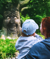Una madre y su hijo observan un árbol parlante con cara en un parque cerca de Hooge Mierde, Brabante Septentrional.