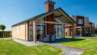 Lodge accessible Eneva à Tusken de Marren, Pays-Bas, jardin verdoyant et terrasse moderne visible.