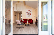 Eingang zur Eneva disabled Lodge mit moderner Einrichtung, rotem Sofa und Blumenbild an der Wand in Holland.