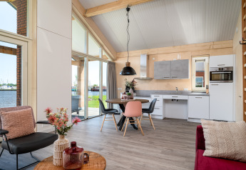 Moderne lodge Eneva disabled ved Tusken de Marren i Holland med køkken, spiseplads og udsigt til vand.