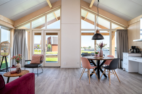 Moderne Eneva disabled lodge bij Tusken de Marren in Nederland, met grote ramen en gezellige inrichting.