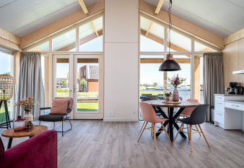 Moderne Eneva disabled lodge bij Tusken de Marren in Nederland, met grote ramen en gezellige inrichting.