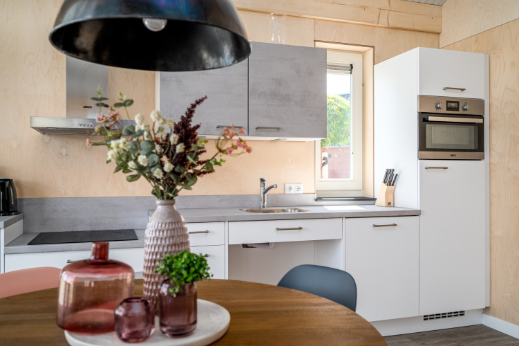 Cocina moderna y accesible en la Eneva lodge de Tusken de Marren, Países Bajos, con flores decorativas.