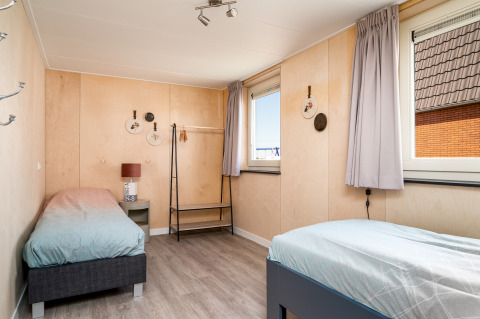 Chambre lumineuse à Eneva disabled lodge, Tusken de Marren, Pays-Bas, avec deux lits simples et déco.