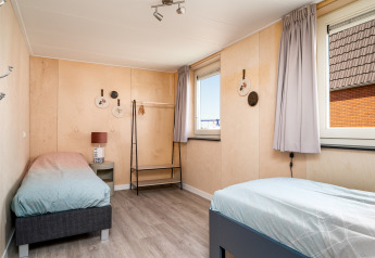 Lichte kamer met twee eenpersoonsbedden bij Eneva disabled lodge, Tusken de Marren, Nederland.