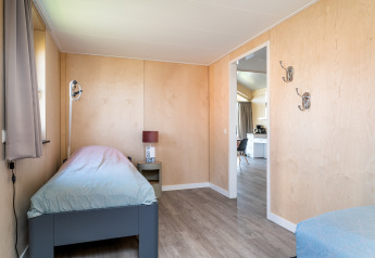 Camera accessibile presso Eneva Lodge, Tusken de Marren, Paesi Bassi, con letto singolo e pareti in legno chiaro.