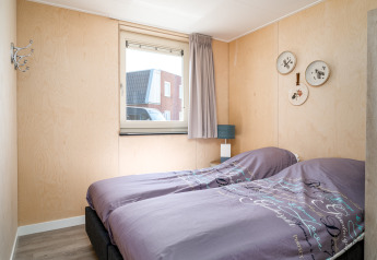 Barrierefreies Schlafzimmer in der Eneva-Lodge bei Tusken de Marren, Niederlande, mit zwei Einzelbetten.