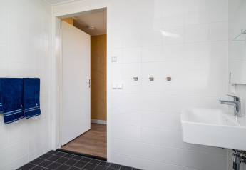 Barrierefreies Badezimmer in der Eneva-Lodge bei Tusken de Marren, Niederlande, mit Handtüchern und Waschbecken.
