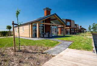 Rolstoelvriendelijke Eneva lodge bij Tusken de Marren, Nederland, met terras, tuin en zicht op het water.