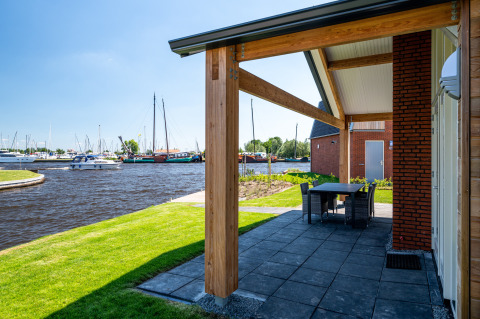 Terrasse avec vue sur le canal et bateaux, Eneva disabled lodge à Tusken de Marren, Pays-Bas.