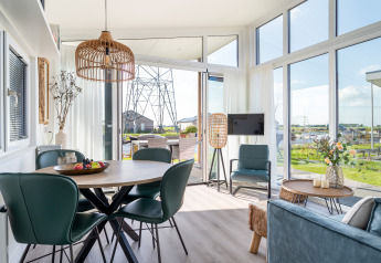 Moderne lodge Knilles aan het water bij Tusken de Marren, Nederland, met grote ramen en gezellige inrichting.