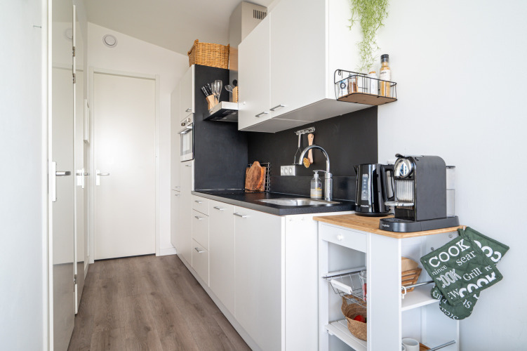 Moderne, kompaktes Küche in Knilles am Wasser bei Tusken de Marren in den Niederlanden, weiße Schränke, Kaffeemaschine.