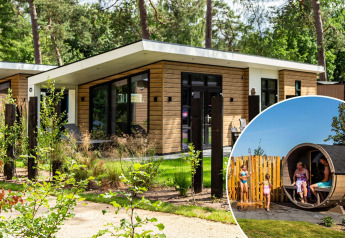 Lodge moderne à Silva sauna avec façade en bois, grandes fenêtres et clients profitant d’un sauna extérieur.