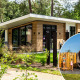 Moderne lodge ved Silva sauna med træfacade, store vinduer og gæster der nyder udendørs saunaoplevelse.