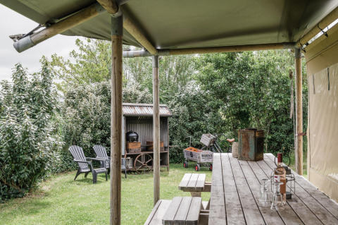 Udendørs spiseplads ved safari teltet Beach Lodge på Duynpark Het Zwanenwater i Holland, omgivet af natur.
