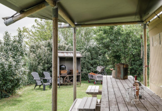 Udendørs spiseplads ved safari teltet Beach Lodge på Duynpark Het Zwanenwater i Holland, omgivet af natur.