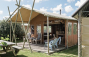 Lodge al aire libre en Duynlodge, Duynpark Het Zwanenwater, Países Bajos, con terraza y sillas de jardín.