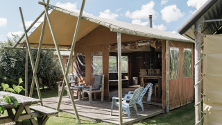 Lodge extérieur à Duynlodge, Duynpark Het Zwanenwater, Pays-Bas, avec terrasse en bois et fauteuils.