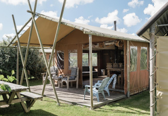 Lodge all’aperto al Duynlodge, Duynpark Het Zwanenwater, Paesi Bassi, con terrazza in legno e sedie.
