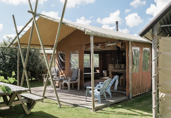 Udendørs lodge ved Duynlodge, Duynpark Het Zwanenwater, Holland, med træterrasse og havemøbler.