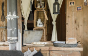 Rustic kitchen scene with wooden counter, metal sink, utensils and lantern at Duynlodge, Duynpark Het Zwanenwater.
