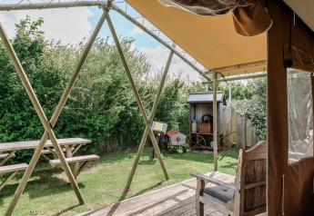 Blick von einer Lodge bei Duynlodge im Duynpark Het Zwanenwater, Niederlande, mit Bank und Garten.