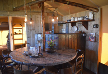 Sala da pranzo rustica e cucina presso Kidz Lodge, Duynpark Het Zwanenwater, Paesi Bassi, atmosfera accogliente.