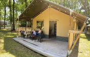 Familia relajándose frente a la Safari tent en Holiday Park Bonte Vlucht, Países Bajos, en verano.
