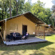 Zwei Kinder sitzen vor einem Safarizelt im Holiday Park Bonte Vlucht in den Niederlanden im Wald.