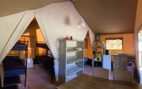 Intérieur d’une tente safari au Holiday Park Bonte Vlucht aux Pays-Bas avec lits superposés et cuisine.