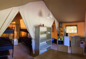 Interieur van een safaritent bij Holiday Park Bonte Vlucht in Nederland met stapelbedden en keuken.