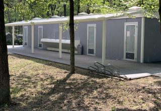 Servizi igienici all'aperto vicino alla tenda safari di Holiday Park Bonte Vlucht nei Paesi Bassi, tra alberi.