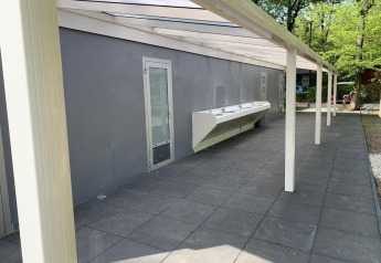 Stazione di lavaggio esterna presso una tenda safari a Holiday Park Bonte Vlucht, Paesi Bassi, tra alberi.