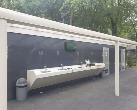 Espace de lavage extérieur près d'une tente Safari au Holiday Park Bonte Vlucht, Pays-Bas, avec lavabos.