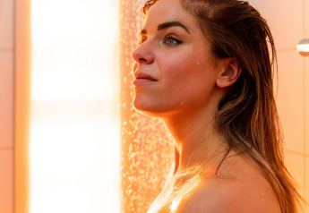 Donna che si gode una doccia rilassante con luce calda nel Wellness Lodge a Hof van Salland, Paesi Bassi.