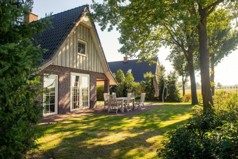Wellness Lodge XL in Hof van Salland, Nederland, met zitje buiten en groene, rustige tuin.