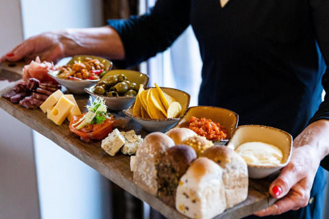 Una bandeja de charcutería con quesos, embutidos y pan en Wellness Lodge XL, Hof van Salland, Países Bajos.