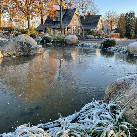 Tiny house Wellness Lodge XL at Hof van Salland, Netherlands, with frosty pond and garden in winter.