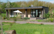 Lodge Culinary bij Resort de Parel in Nederland, moderne lodge met terras, omringd door natuur en bomen.