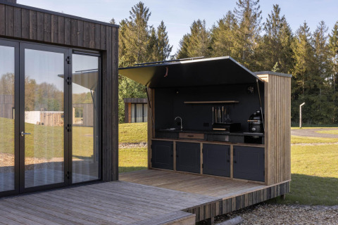 Outdoor kitchen at Lodge Culinary, Resort de Parel, Netherlands, featuring modern wood and glass design.