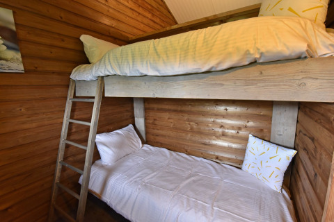 Chambre chaleureuse avec lits superposés et murs en bois à la cabane du Camping de Koeksebelt, Pays-Bas.